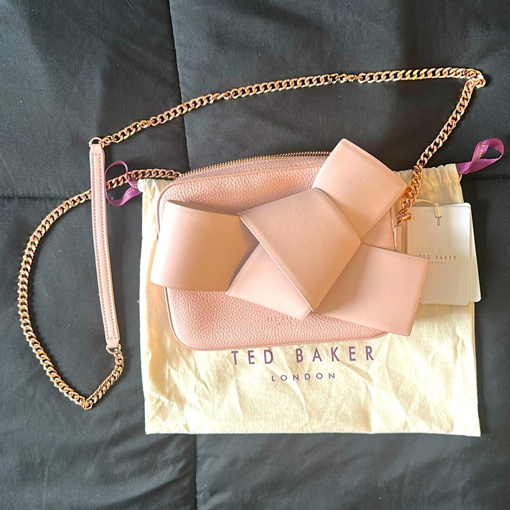 Never used,gorgeous baby pink Ted Baker camera bag.

Leather, NWT, dust bag